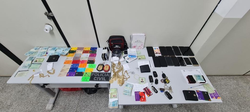 Objetos e dinheiros apreendidos com bando em Cuiabá — Foto: Polícia Civil