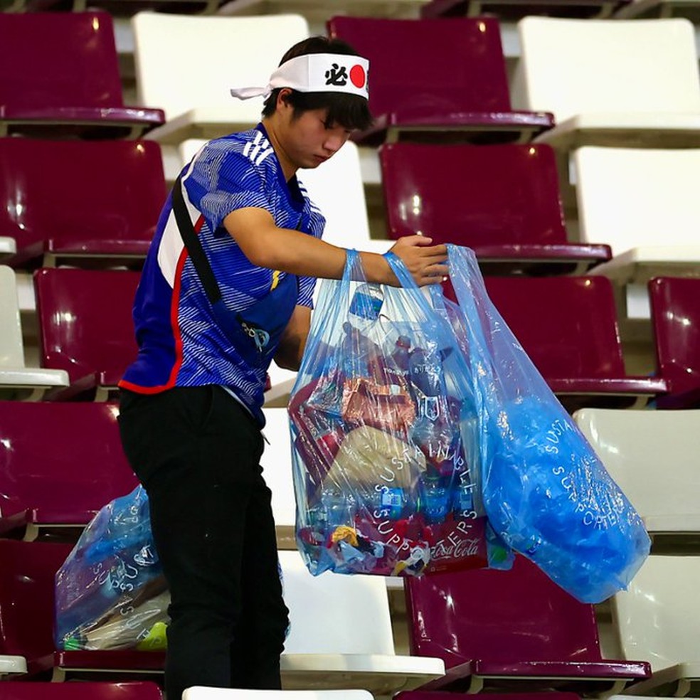 Japoneses limpam estádio após vitória sobre a Alemanha — Foto: FIFA