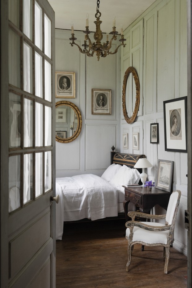 View through open doorway to charming bedroom with wooden wall panelling and french antiques (Foto: Getty Images)