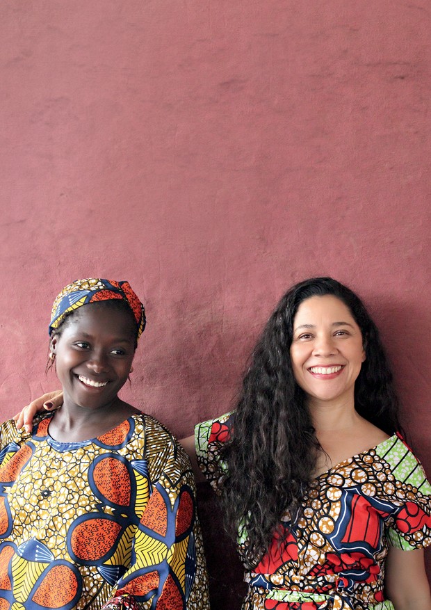 Katia, à direita, com Segunda Naçana em Guiné-Bissau. As duas usam vestidos que confeccionaram na oficina de costura montada pela brasileira no país africano (Foto: Fátima Rodrigues)