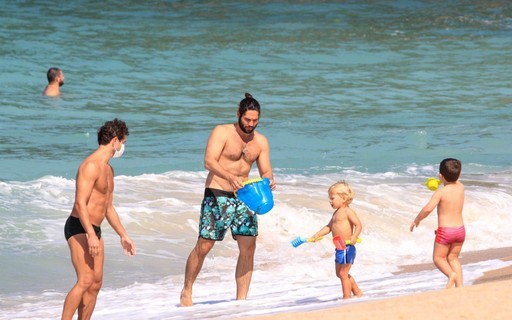 Galãs Paulo Rocha e Dudu Azevedo curtem praia no Rio com família