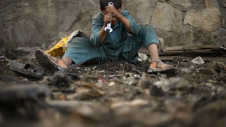 Criança usa uma chave inglesa enquanto procura sucata em Cabul, Afeganistão  — Foto: DANIEL LEAL / AFP