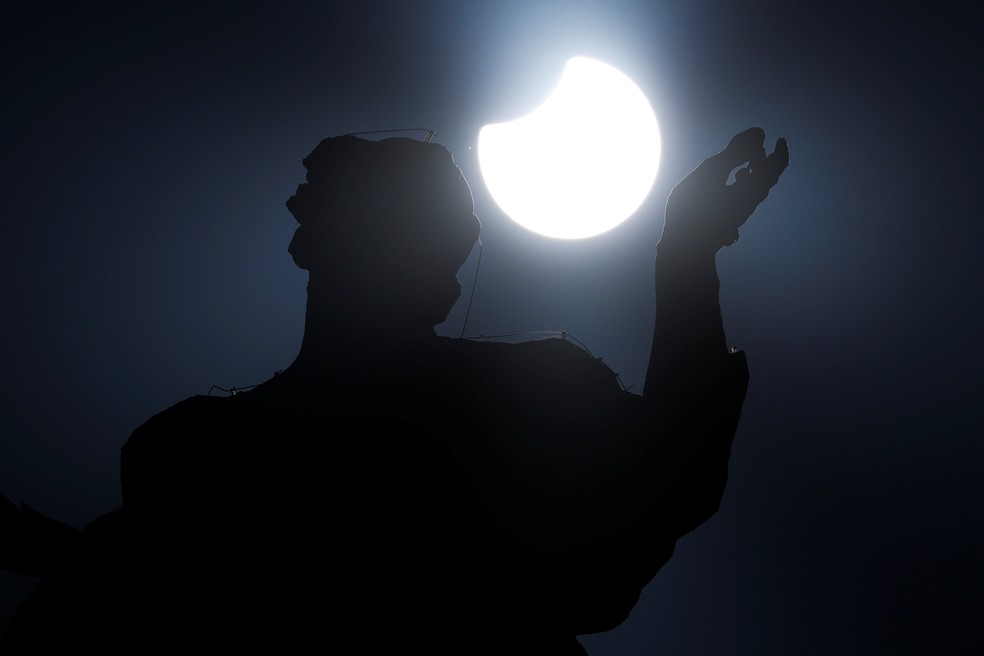 Uma estátua na Praça de São Pedro, no Vaticano, é encoberta pelo eclipse parcial do Sol nesta terça (25). — Foto: REUTERS/Guglielmo Mangiapane