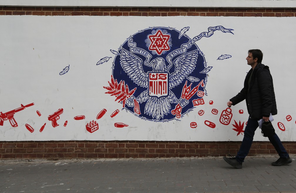 Homem passa em frente a um mural pintado na parede da ex-embaixada dos Estados Unidos em Teerã, no Irã, em janeiro de 2020. — Foto: Atta Kenare/AFP