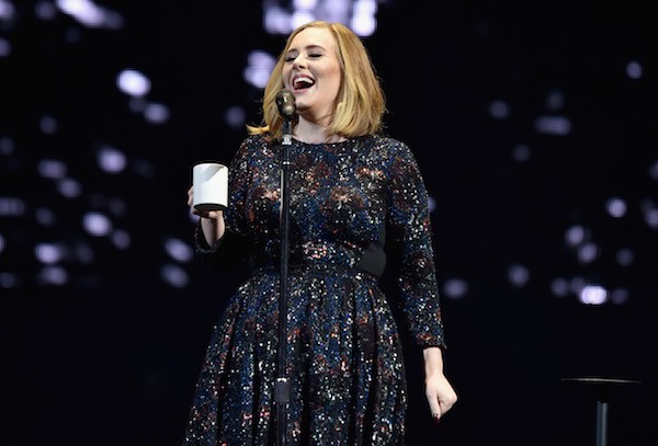 A cantora Adele segura uma xícara durante uma apresentação recente (Foto: Getty Images)