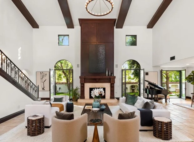SALA DE ESTAR | A sala de estar possui estilo hispânico bem pontuados, com paredes brancas e tons terrosos (Foto: Reprodução / Zillow)