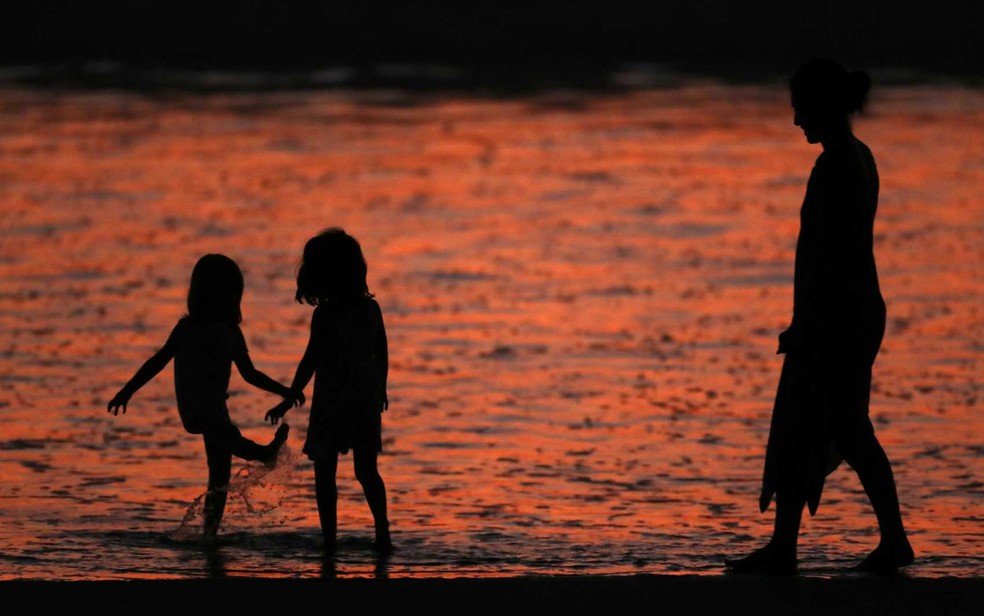 Família se refresca na praia de Cardiff, sul da Califórnia (Foto: Mike Blake / Reuters)