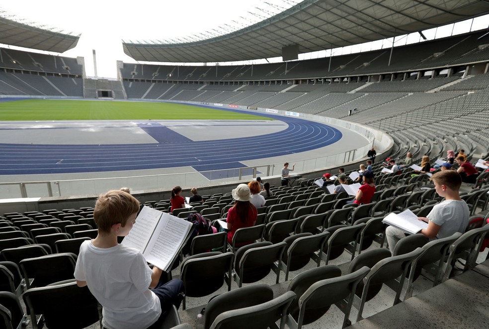Devido às restrições do coronavírus e para manter a distância obrigatória entre os cantores, a ópera mudou ensaios para a arquibancada principal do Estádio Olympiuc em Berlim, na Alemanha. Foto do dia 23 de setembro — Foto:  Michael Sohn/AP