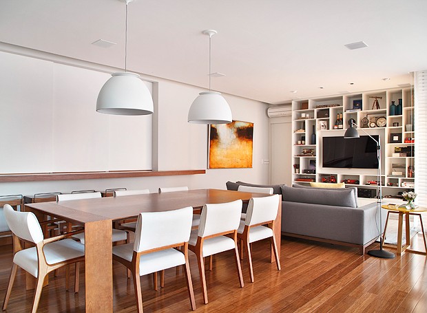 A sala de jantar tem mesa de madeira e pendentes brancos, que tornam o espaço bem clean e confortável (Foto: MCA Estúdio)