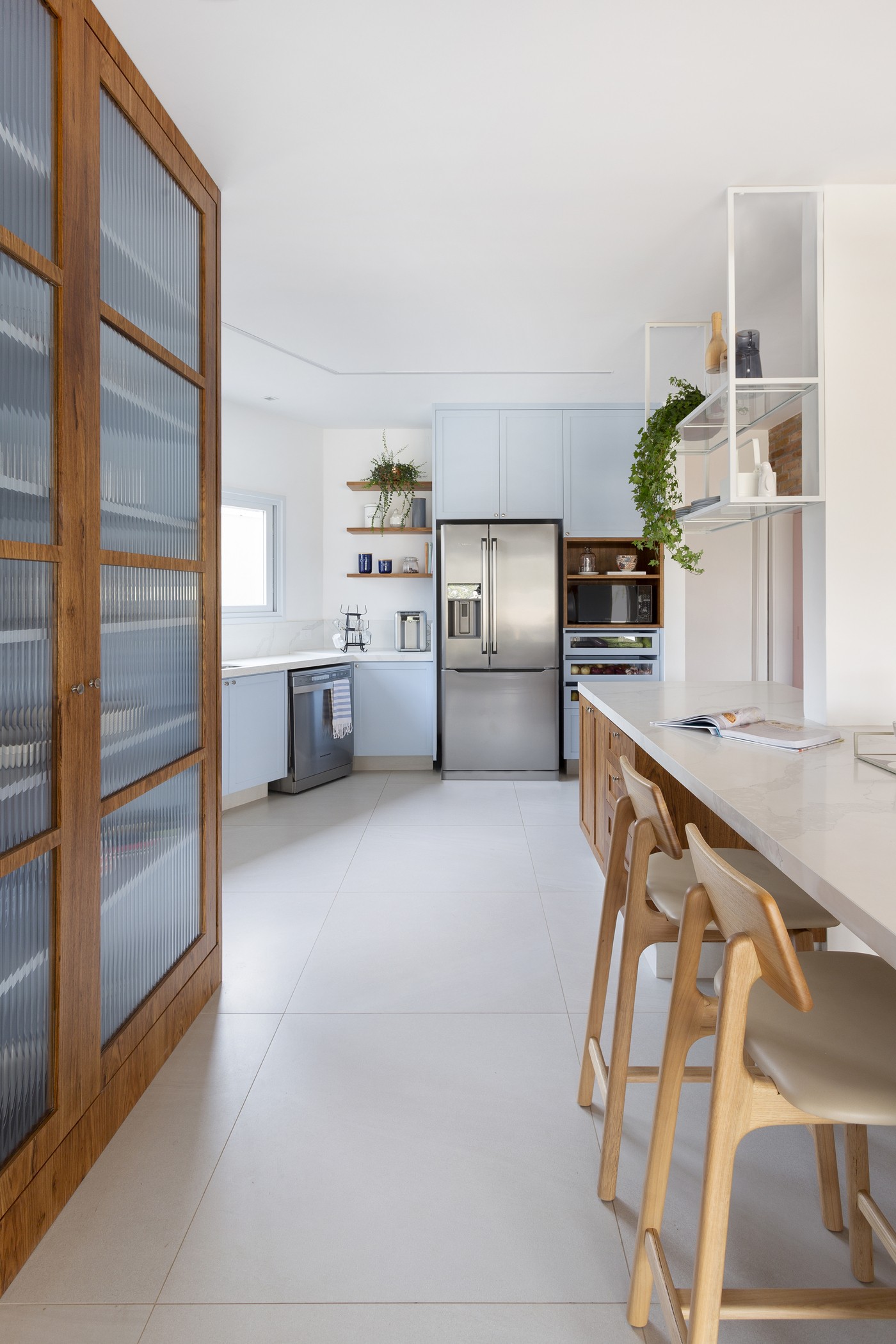 Décor do dia: cozinha aberta tem armários azuis, ilha central e parede de tijolinhos (Foto: Julia Ribeiro)