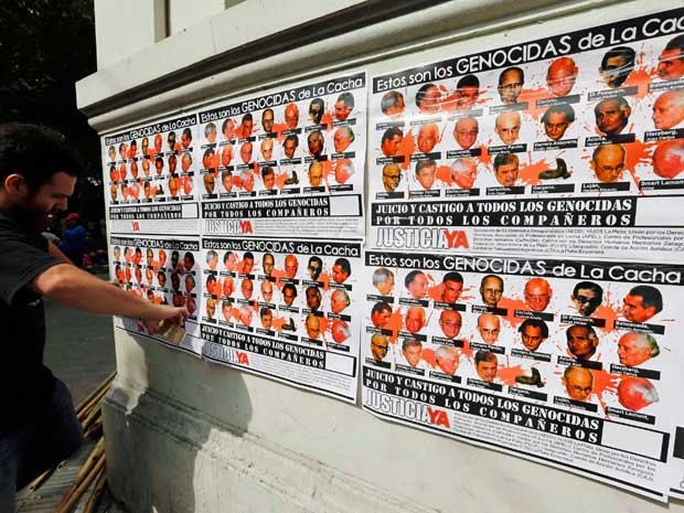 Cartazes mostram supostos genocidas que atuaram em ‘La Cacha’. (Foto: Enrique Marcarian / Reuters)