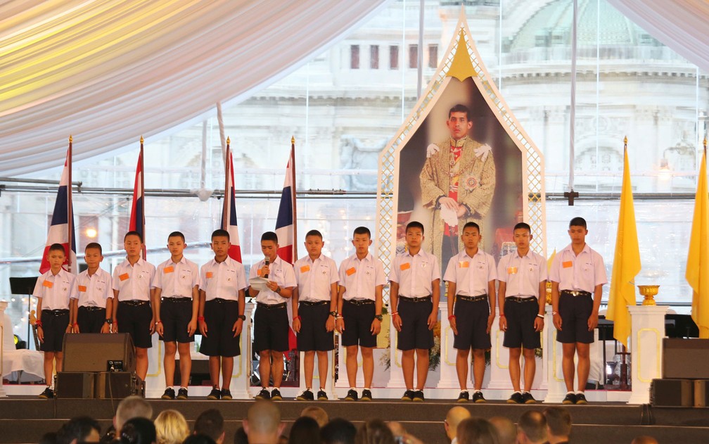 Integrantes do time ‘Javalis Selvagens’ fazem agradecimento em frente ao retrato do rei da Tailândia, Maha Vajiralongkorn Bodindradebayavarangkun, durante evento intitulado ‘Unidos como um’, em  Bangcoc, na quinta-feira (6) (Foto: AP Photo/Sakchai Lalit)