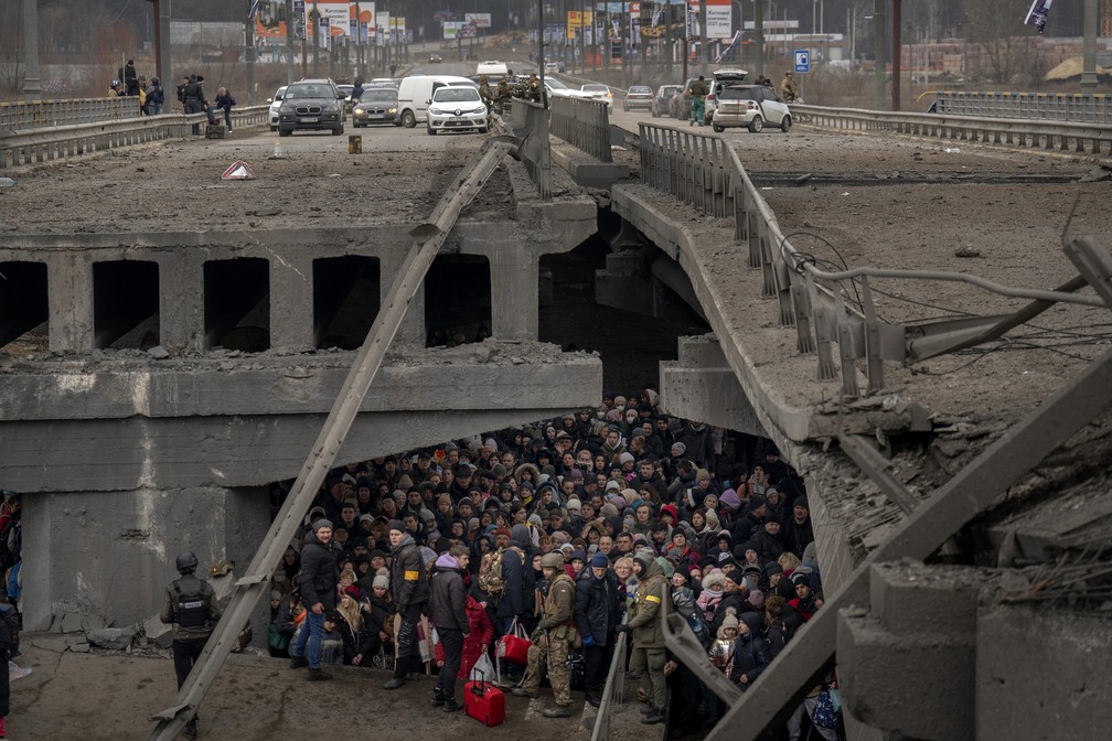 5 de maro - Ucranianos se amontoam sob uma ponte destruda enquanto tentam fugir cruzando o rio Irpin, nos arredores de Kiev, na Ucrnia — Foto: Emilio Morenatti/AP