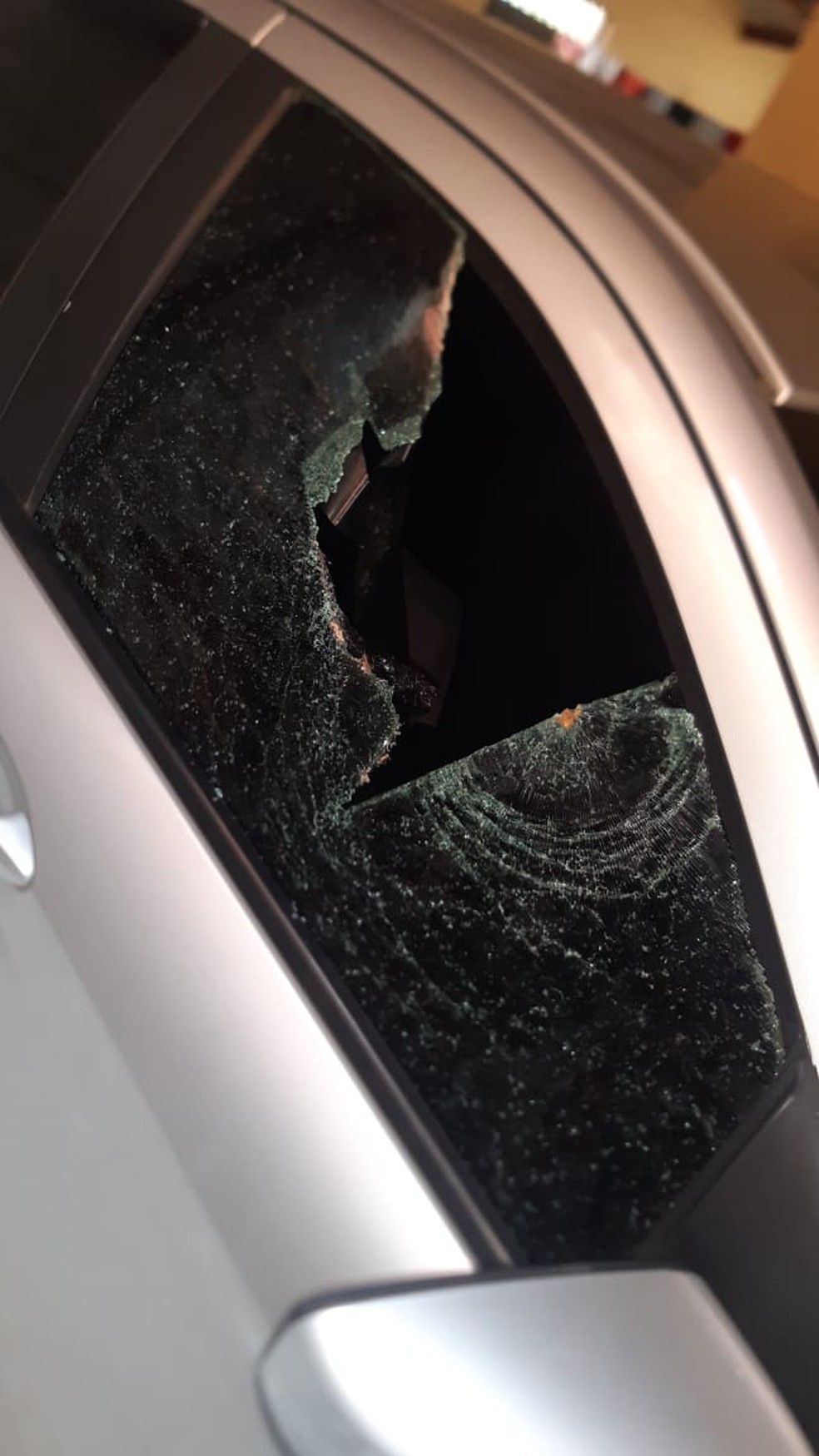 Pedra atingiu lateral do carro e feriu criança que estava no banco traseiro — Foto: Whatsapp/Reprodução