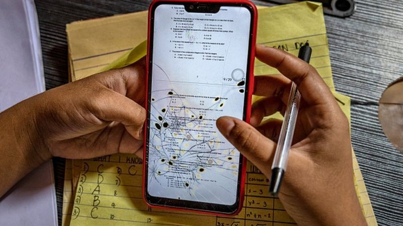 Para a maioria dos estudantes, acesso às aulas e ás atividades foi feito pelo celular, muitas vezes compartilhado por toda a família (Foto: Getty Images via BBC News)
