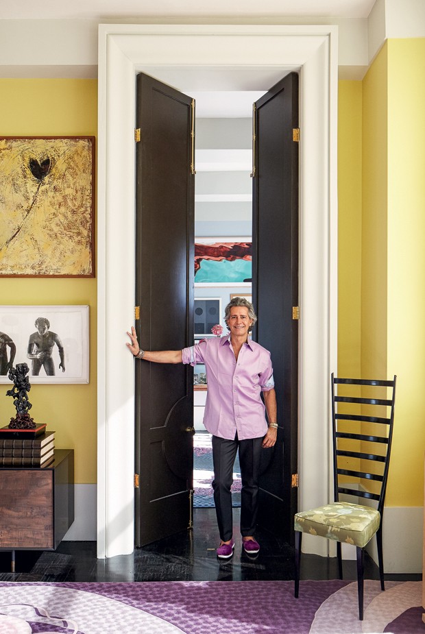 Cacá abre as portas de seu apartamento em Midtown east. na parede, tela Black Tulip da amiga sylvia Martins e foto de Fernando Bengoechea. (Foto:  )