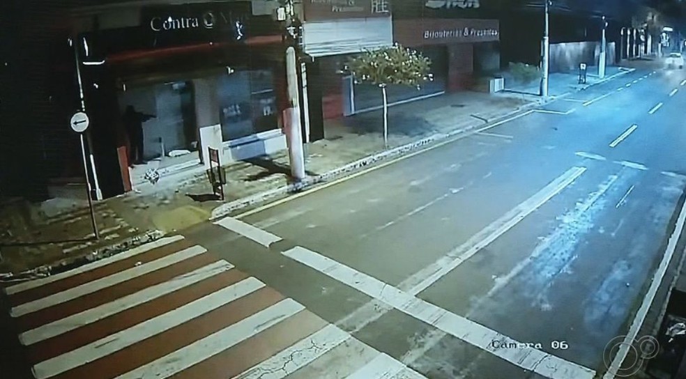Em uma das imagens é possível ver o criminoso atirando de dentro de uma loja no centro de Ourinhos  — Foto: TV TEM/ Reprodução 