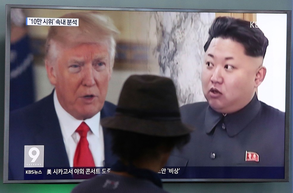 Homem observa imagem do presidente americano, Donald Trump, e do líder norte-coreano, Kim Jong-un, em Seul, na Coreia do Sul  (Foto: Ahn Young-joon/ AP)
