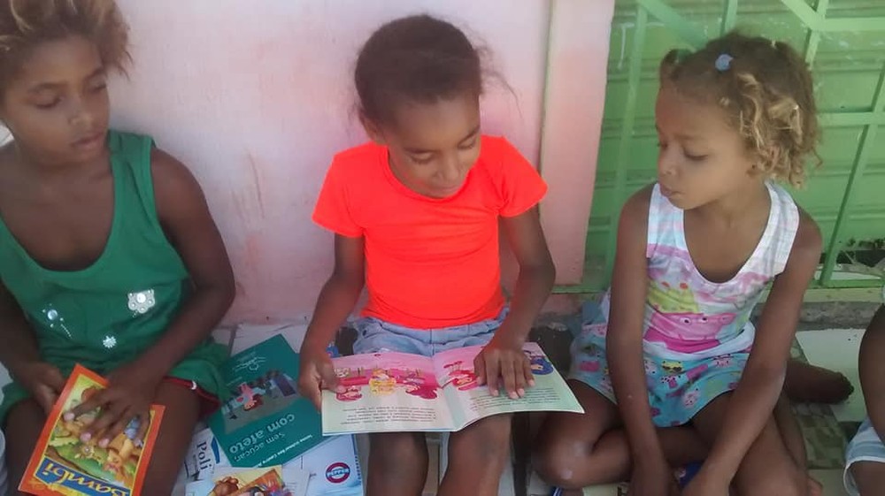 Mesmo em um local improvisado, as crianças parecem encantadas com  as histórias descobertas nos livros (Foto: Mara Lúcia de Paula)