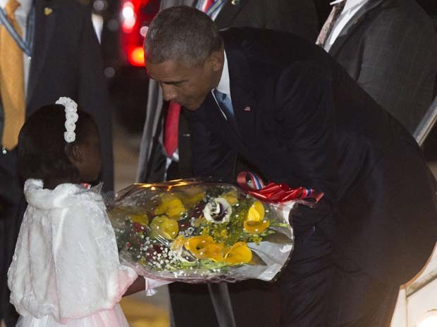 Obama ganha ramo de flores de menina ao chegar nesta sexta-feira (24) no Quênia (Foto: AFP PHOTO / SAUL LOEB)