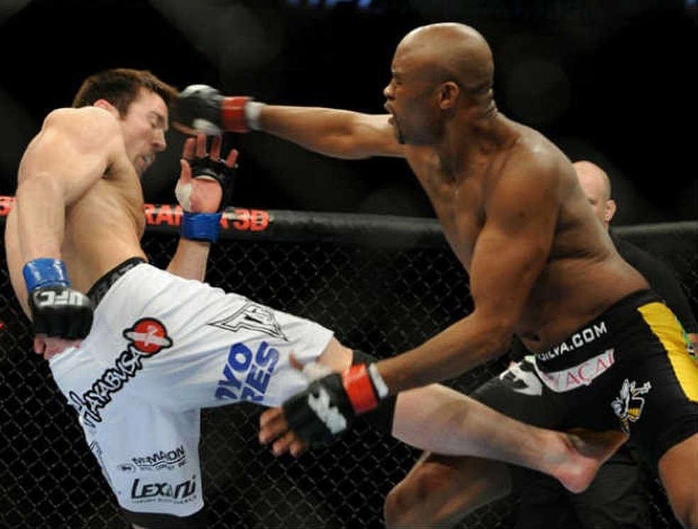 Anderson Silva (dir.) e Chael Sonnen (esq.) trocam golpes no minuto inicial da luta — Foto: Divulgação/UFC