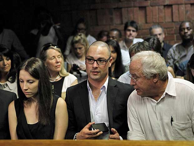 Irmãos de Oscar Pistorius, Aimee e Carl, e o pai Henke aguardam o reinício da audiência em pretória. (Foto: Siphiwe Sibeko / Reuters)