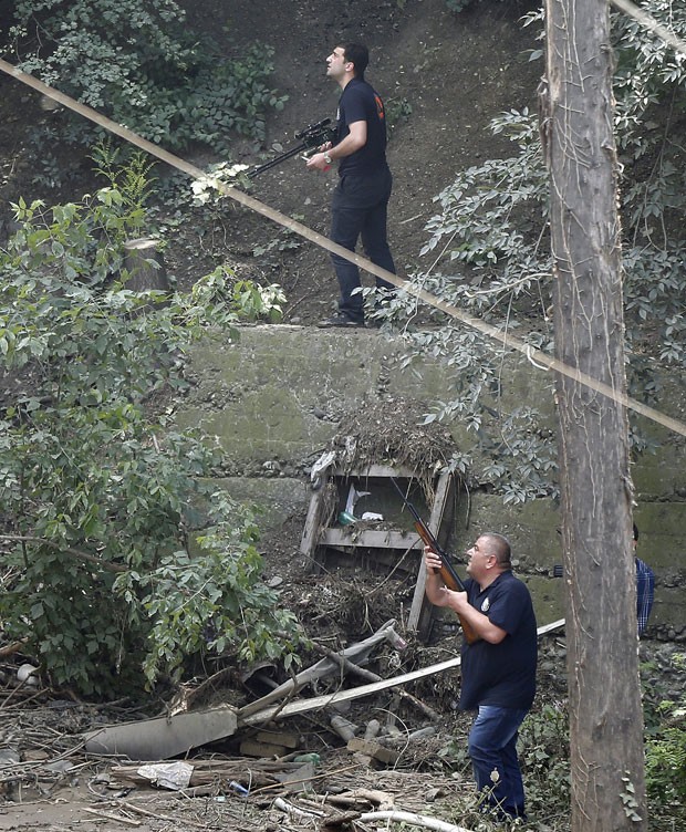  Policiais armados buscam tigre branco que matou homem na Georgia nsta quarta-feira (17) (Foto: David Mdzinarishvili/Reuters)