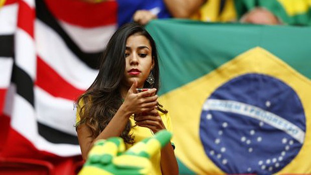Torcedora confere mensagem no celular durante a Copa do Mundo no Brasil ; geração Y no Brasil ; millenial ; tecnologia ; smartphone ;  (Foto: Dominic Ebenbichler/Reuters)
