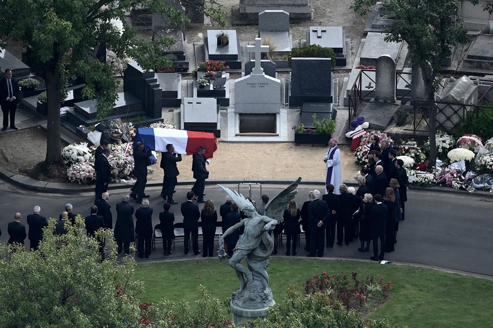 Caixão de Chirac é carregado no cemitério de Montparnasse, em Paris, para funeral privado nesta segunda-feira (30). — Foto: Philippe Lopez/AFP