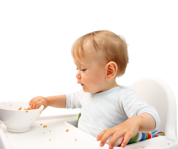 Criança com a mão na comida  (Foto: Thinkstock)