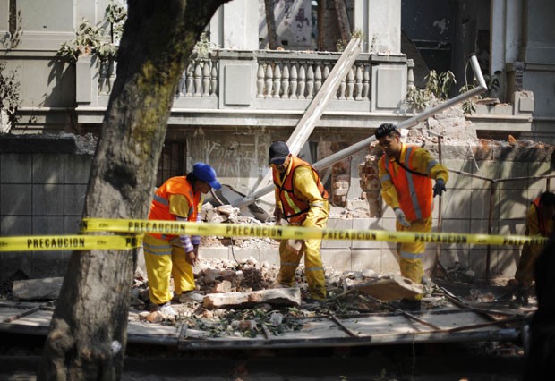 Funcionários da prefeitura removem destroços de uma parede que desabou devido ao terremoto na Cidade do México (Foto: Bernardo Montoya/Reuters)