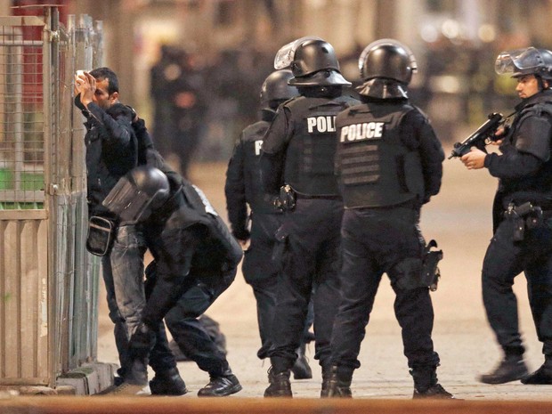 Polícia francesa revista um rapaz durante operação no norte de Paris (Foto: Christian Hartmann / Reuters)