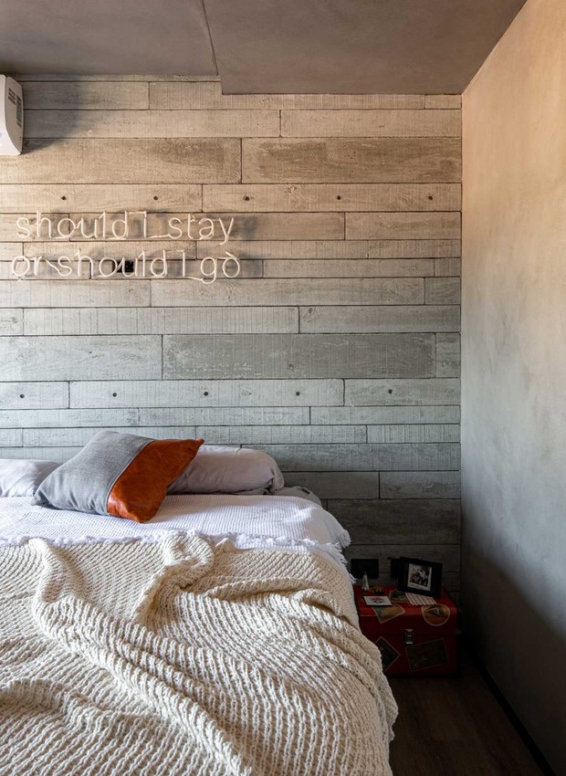 QUARTO | Com estilo industrial, o quarto do casal recebeu revestimento de placas de concreto da Castelatto na cabeceira e tinta Cromio, da Suvinil, nas paredes (Foto: Favaro Jr. / Divulgação)