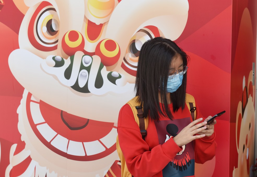 Pedestre cobre o rosto com máscara sanitárias após a confirmação dos primeiros casos de coronavírus em Hong Kong, China. Foto de 23 de janeiro de 2018. — Foto: Miguel Candela Poblacion/Anadolu Agency