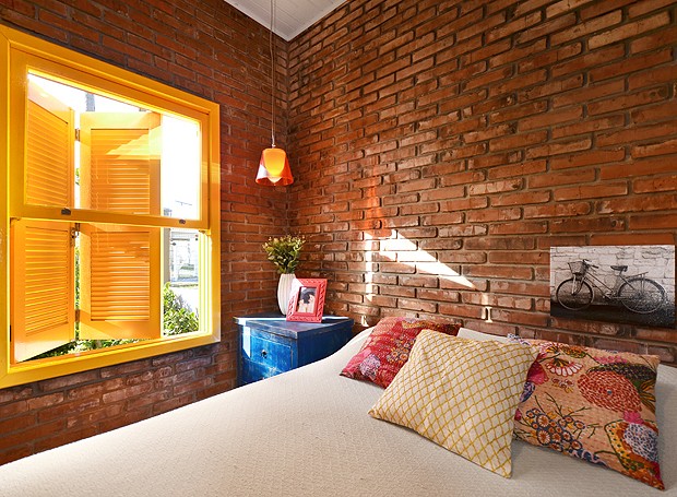 Para combinar com o clima praiano, um dos quartos tem parede com tijolos à mostra, no maior estilo rústico (Foto: Vanessa Bohn/Bohn Fotografias)