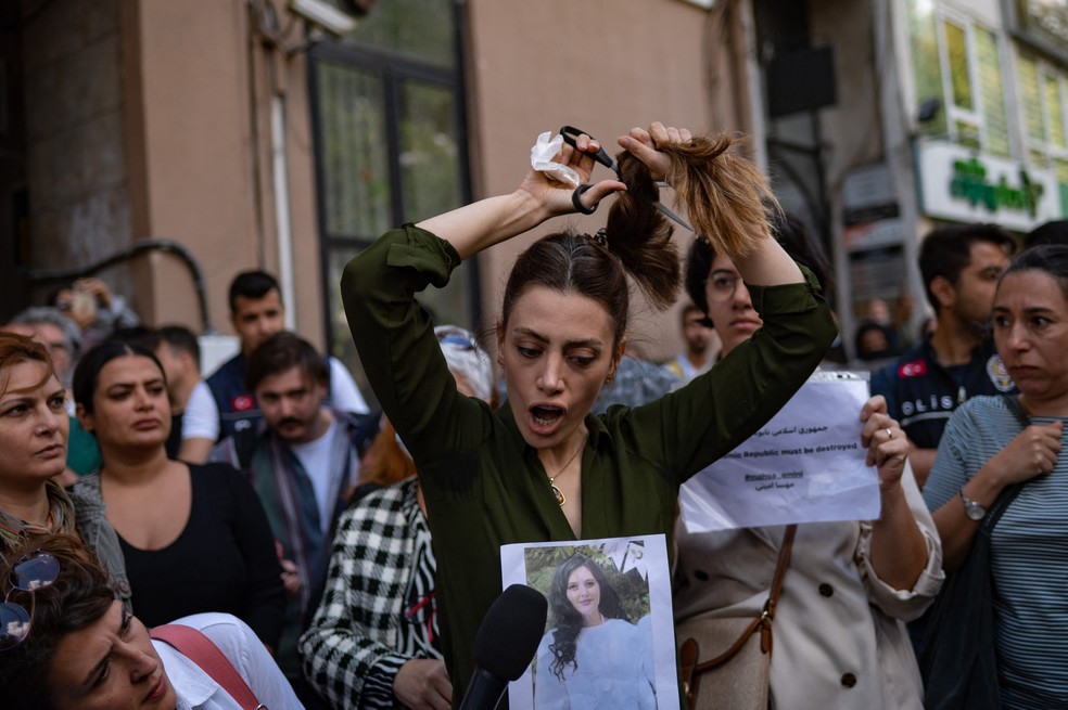 Em Istambul, mulher corta o cabelo em público como forma de protesto contra o governo do Irã — Foto: Yasin AKGUL / AFP