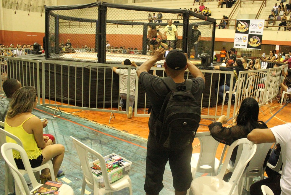 Vendedor de balas aproveita um momento de descanso para filmar um combate (Foto: Marcelo Barone )