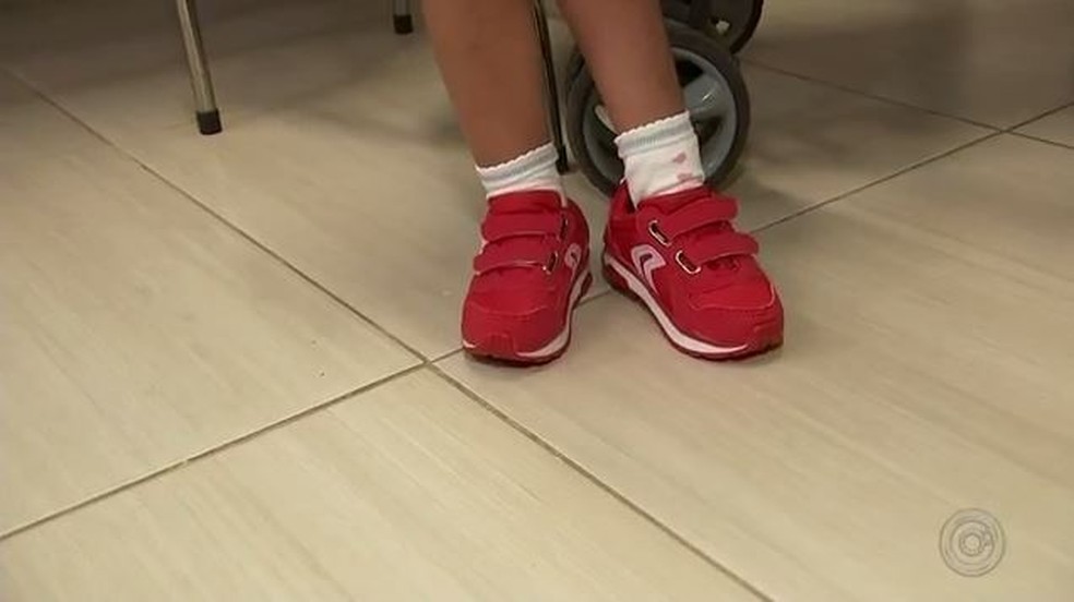 Menina realizou uo sonho de colocar os dois pÃ©s no chÃ£o calÃ§ando sapato vermelho apÃ³s tratamento em Rio Preto (SP) â Foto: ReproduÃ§Ã£o/TV TEM