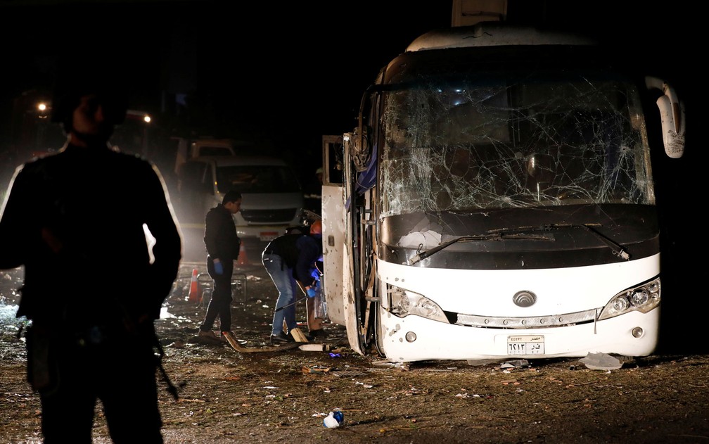 Policiais sÃ£o vistos ao lado de Ã´nibus atingido por bomba perto de GizÃ©, no Egito, na sexta-feira (28) â€” Foto: Reuters/Amr Abdallah Dalsh