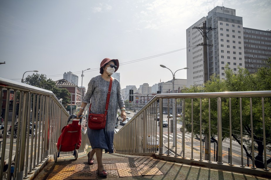 Mulher caminha pela rua em Pequim, na China