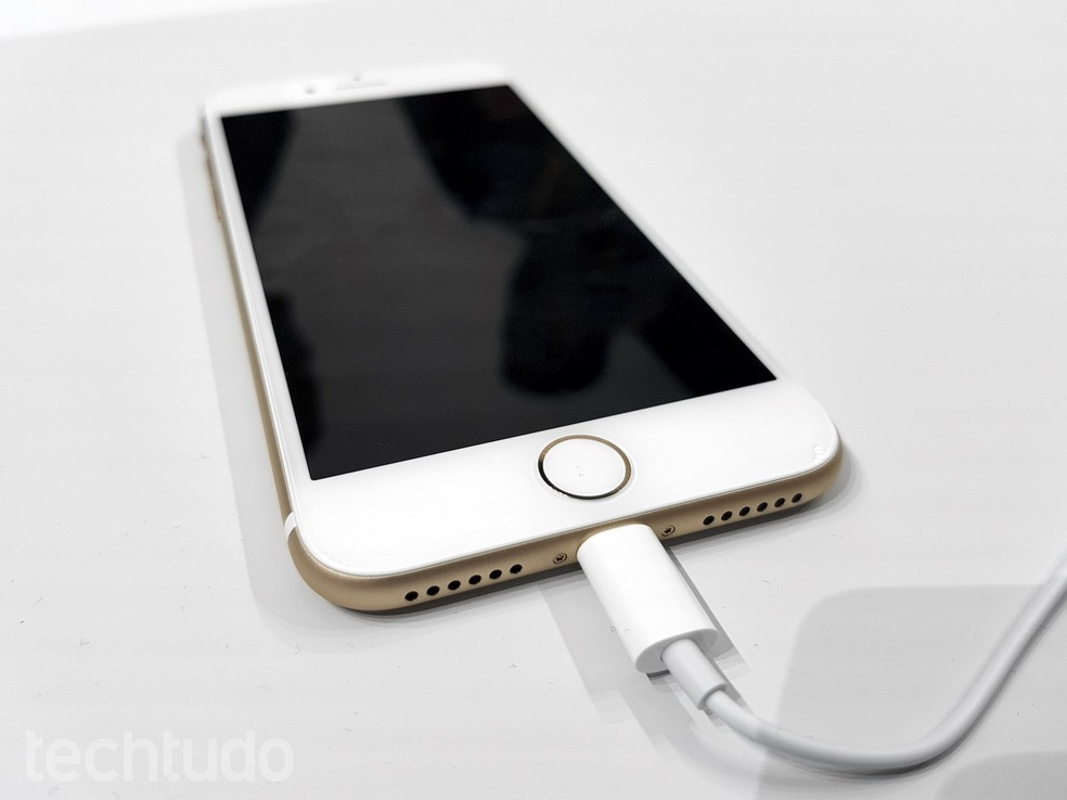 iPhone 7 dourado conectado ao cabo Lightning — Foto: Thássius Veloso/TechTudo