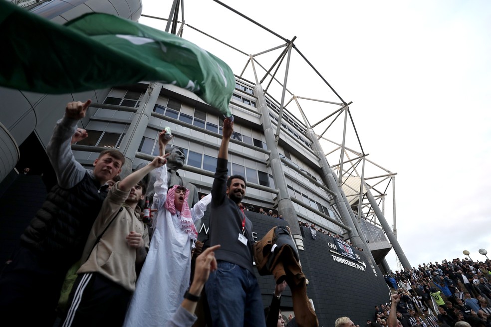 Torcedores agitam bandeira da Arábia Saudita na comemoração da compra do clube inglês por fundo de investimento do país asiático em frente ao estádio St James' Park — Foto: Reuters/Lee Smith
