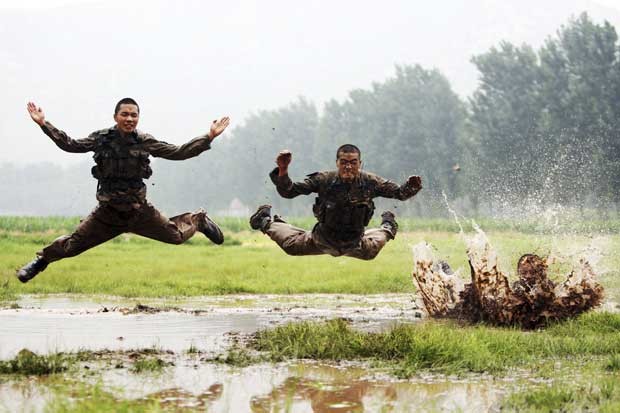 Em treinamento, soldados chineses saltam na lama. (Foto: China Daily/Reuters)