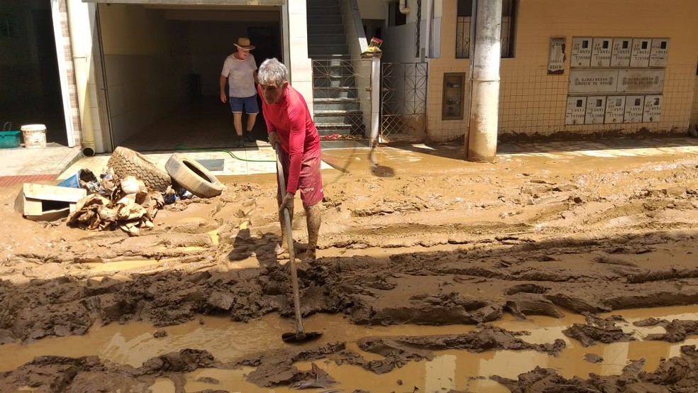 Morador de Alfredo Chaves puxa lama de rua, no Sul do ES  — Foto: Kaique Dias/ TV Gazeta 