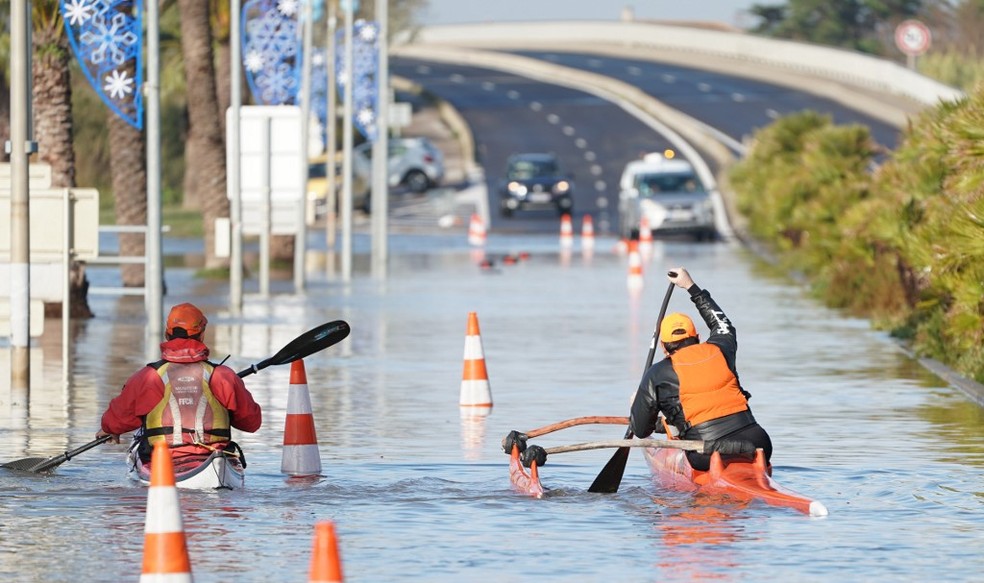 Dois homens circulam de canoa em rua da cidade de Palavas-les-Flots, no Sul da França, depois de inundações — Foto: Pascal Guyot/AFP