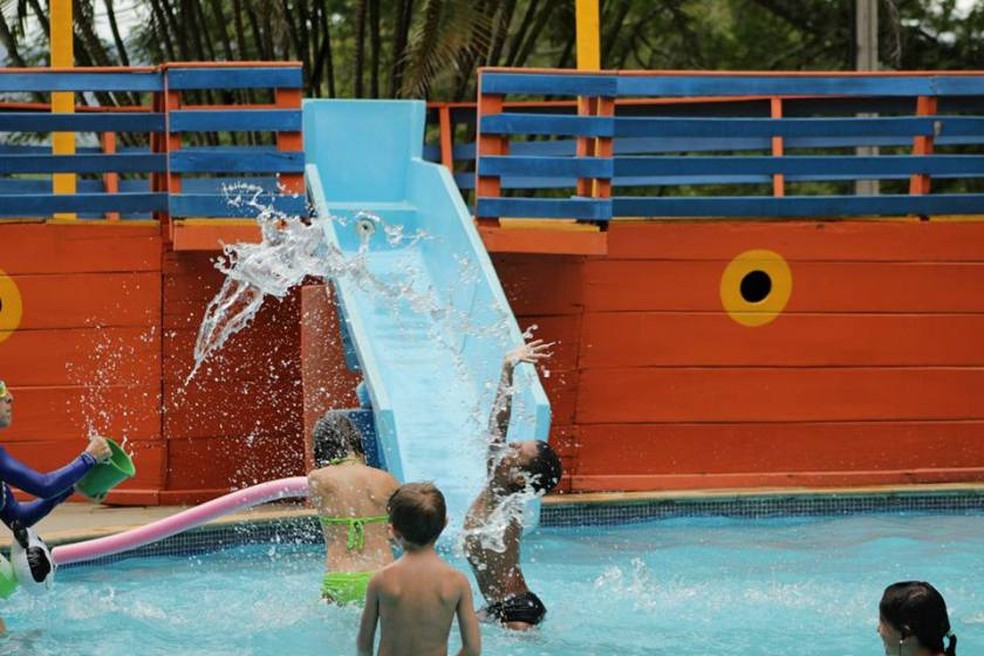 Piscina com água climatizada em formato de navio pirata; crianças se divertem escorregando e brincando — Foto: Eldorado Eco Resort/ Divulgação