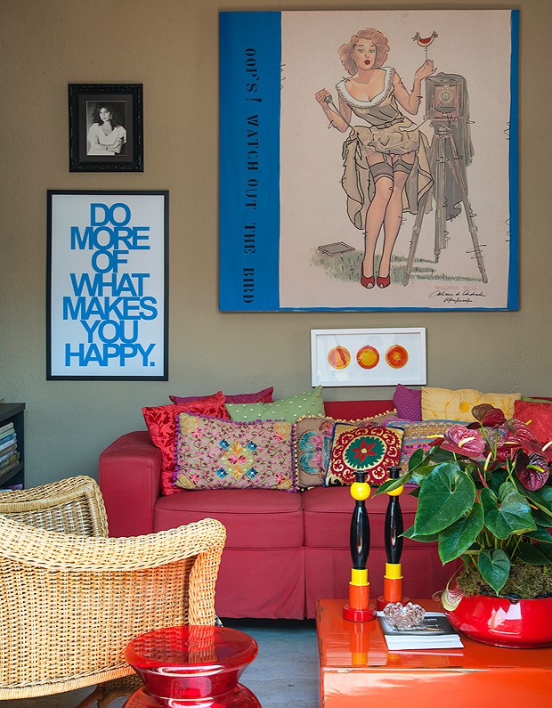 Muitos quadros cobrem as paredes da casa. Detalhe para o sofá da sala de Tv, que traz almofadas de todos os tamanhos e estilos (Foto: Divulgação/Romulo Fialdini)