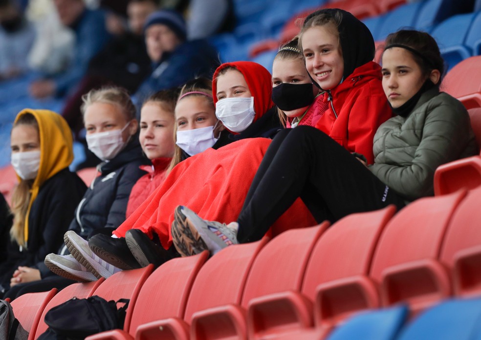 Jovens com máscaras assistem à partida de futebol da Liga Principal Feminina de futebol em Minsk, em Belarus, na quinta-feira (30)  — Foto: Sergei Grits/AP