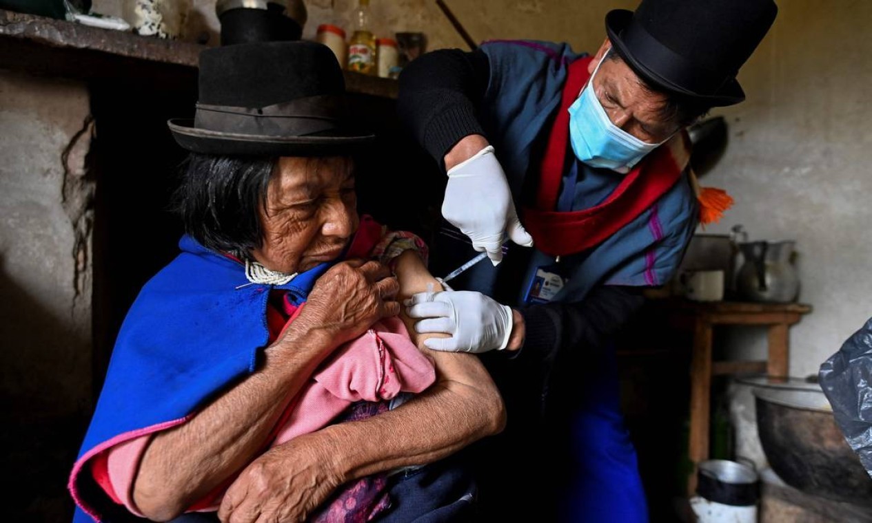 Enfermeira indígena da etnia Misak Anselmo Tunubala, 49, inocula uma idosa indígena com vacina Sinovac contra COVID-19 na reserva indígena Guambia, zona rural de Silvia, departamento de Cauca, Colômbia — Foto: LUIS ROBAYO / AFP