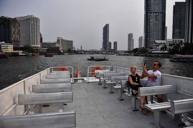 BBC - Um casal anda de barco em um passeio turístico no rio Chao Phraya em Bangkok, Tailândia, onde o número de visitantes caiu drasticamente (Foto: LILLIAN SUWANRUMPHA / AFP via BBC)